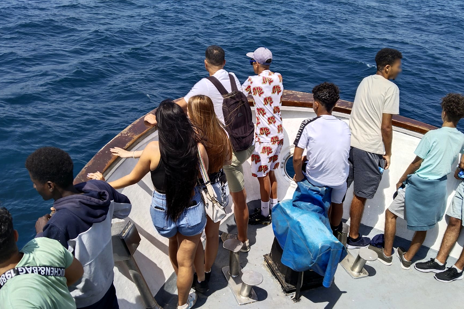 El grupo de jóvenes contempla el mar desde la proa del barco