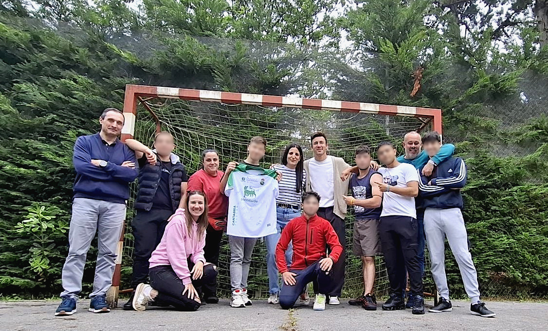Saúl, junto a jóvenes y profesionales de Parayas, mostrando la camiseta firmada del Racing