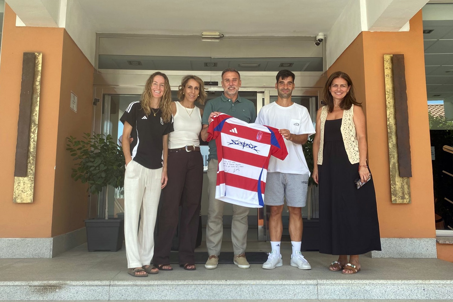 El equipo del centro posa con una de las camisetas donadas por el club