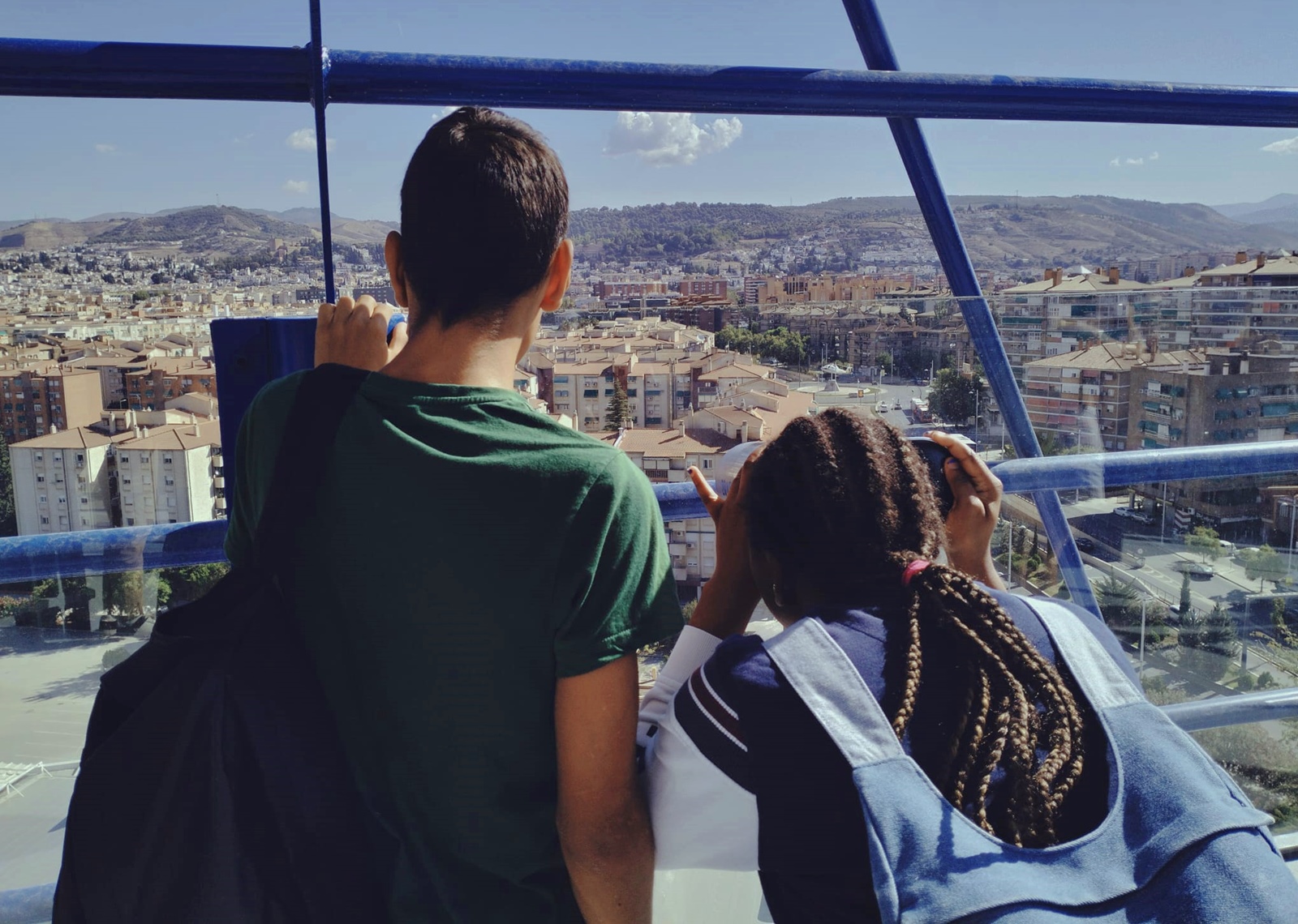 Dos jóvenes observan las vistas de Granada desde lo alto del Parque