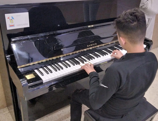 Un joven se sienta al piano para interpretar un tema
