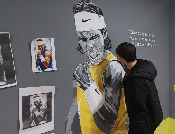 Un joven completa el retrato de Rafa Nadal que decora la sala