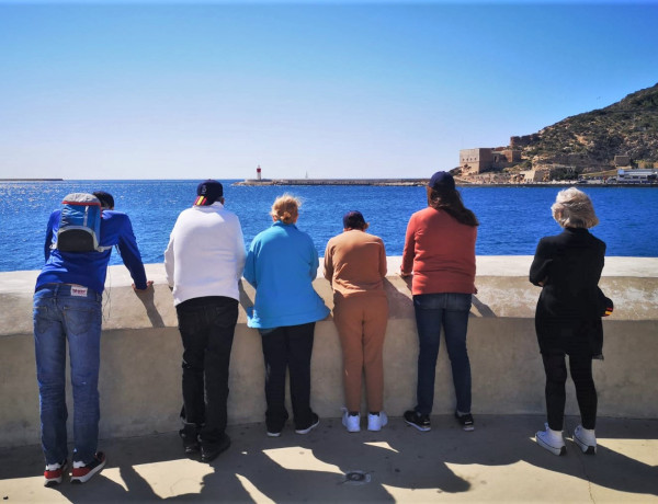 Un grupo de hombres y mujeres del centro contemplan el Puerto de Cartagena