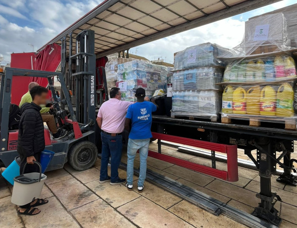 Los dos jóvenes ayudan a otros voluntarios a llenar el camión