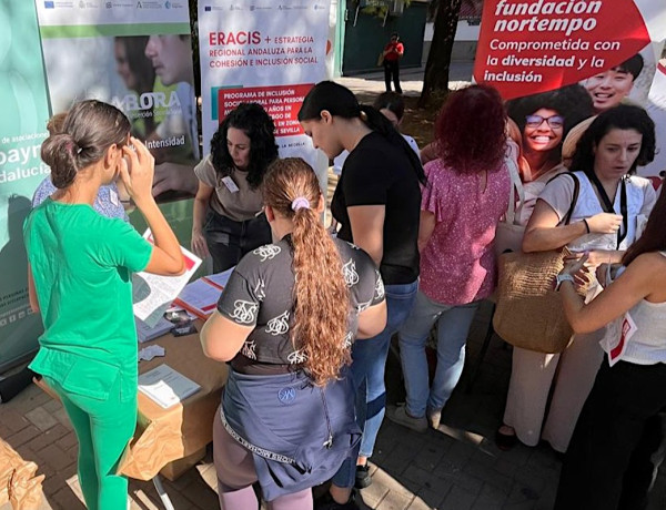 Varias personas se acercan a la mesa informativa de Fundación Diagrama