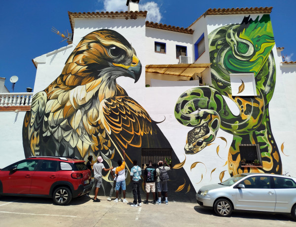 Los jóvenes observan uno de los murales de la localidad