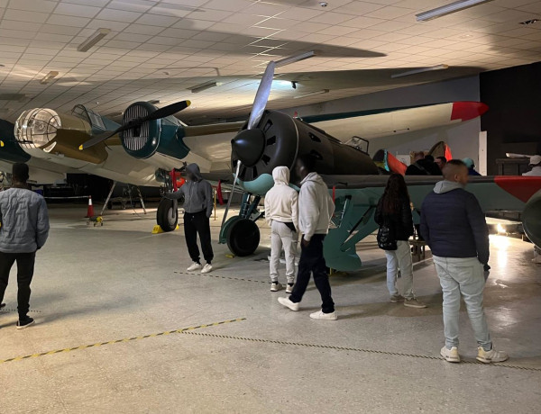 Varios jóvenes observan el hangar con aviones de la época