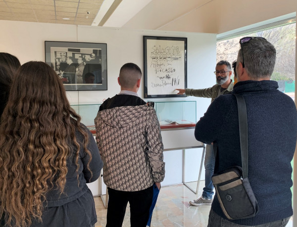 Luis Fernández muestra a los jóvenes uno de los carteles expuestos