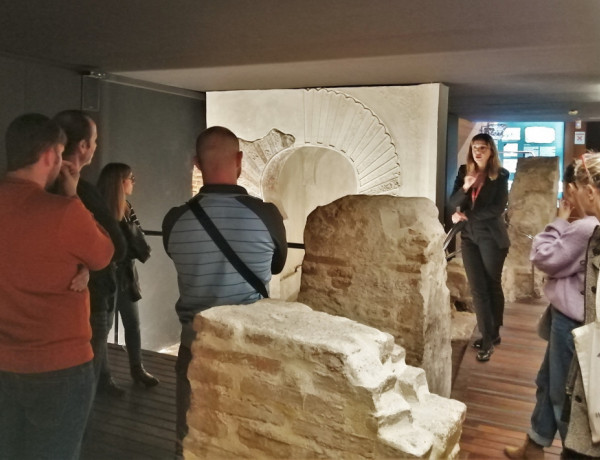 Una guía del museo explica una de las piezas a las personas que participan en la visita