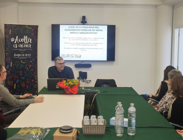 Un profesional del programa ofrece información a las familias asistentes