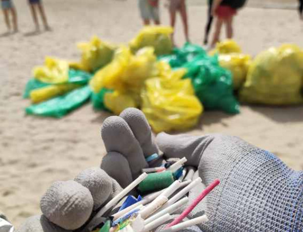 Jóvenes de la residencia de acogida ‘La Pobla’ de La Pobla de Vallbona (Valencia) colaboran en una jornada de limpieza en la playa de Pinedo