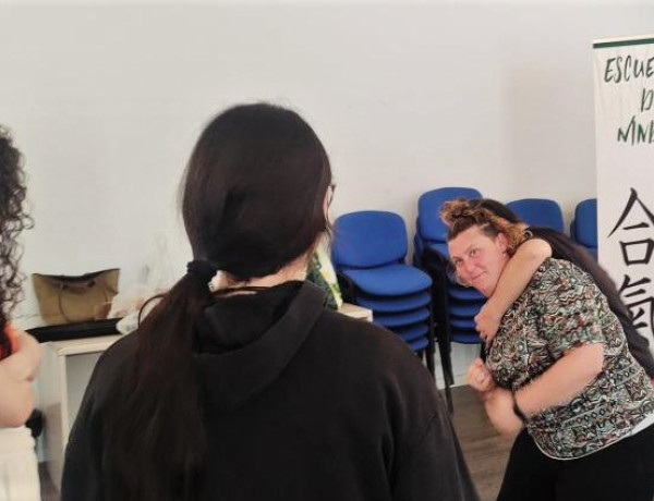 Dos jóvenes presencian la demostración de una técnica para defenderse