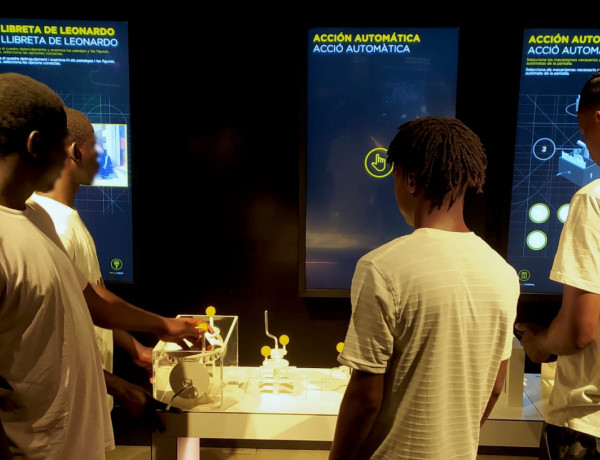 Los cuatro jóvenes prueban uno de los juegos interactivos de la exposición