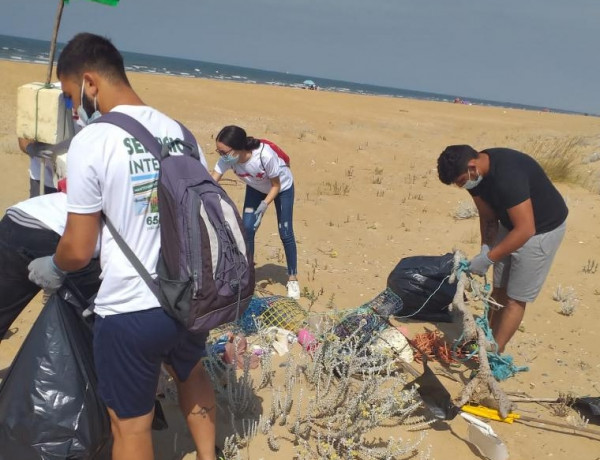 Los menores del centro ‘Odiel’ de Huelva participan en una actividad de voluntariado medioambiental en la playa de las marismas