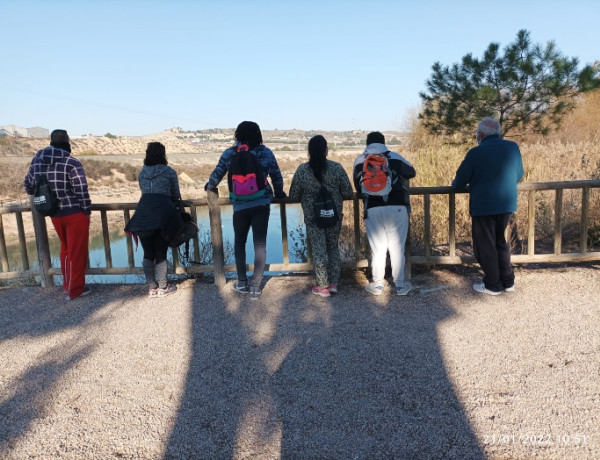 Grupo de 6 personas participantes en la ruta senderista observan el río desde un mirador
