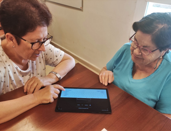 Dos residentes aprenden cómo se utiliza el teclado de la tablet