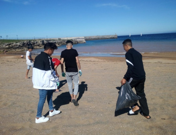 Los jóvenes atendidos en el centro ‘Villa Ana’ en Avilés (Asturias) participan en una actividad de recogida de residuos en las playas de Luanco 