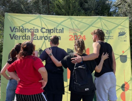 Jóvenes de Campanar, frente al cartel de la jornada medioambiental