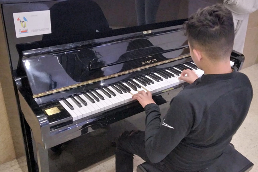 Un joven se sienta al piano para interpretar un tema