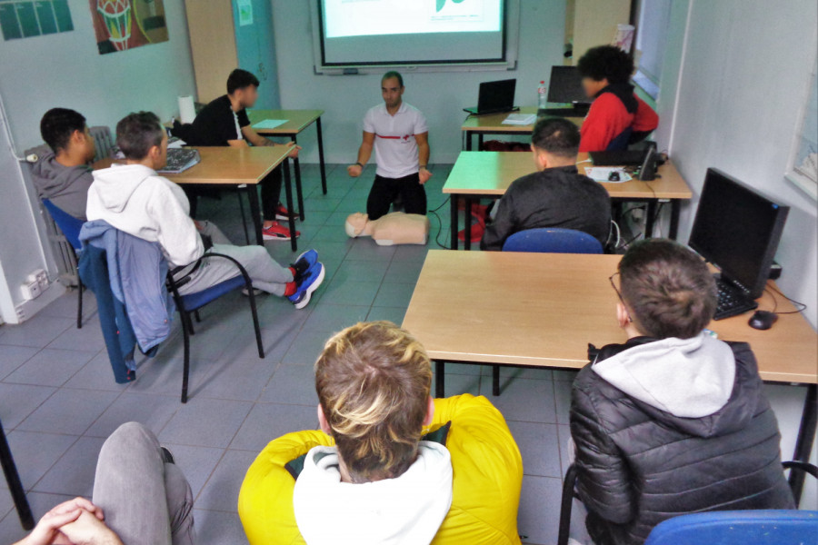 El grupo de jóvenes escucha las explicaciones sobre reanimación cardiopulmonar