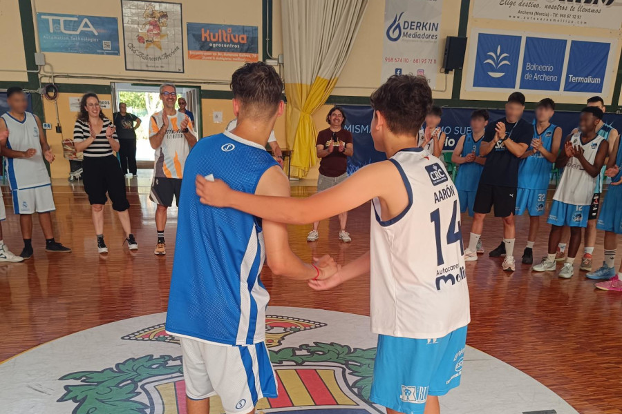 Dos jóvenes de equipos contrarios se dan la mano al final del partido