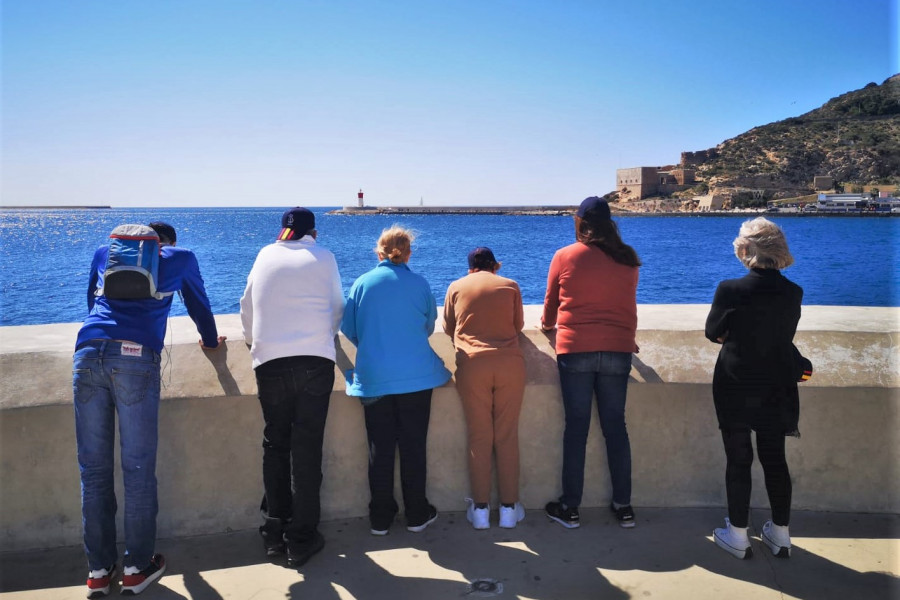 Un grupo de hombres y mujeres del centro contemplan el Puerto de Cartagena