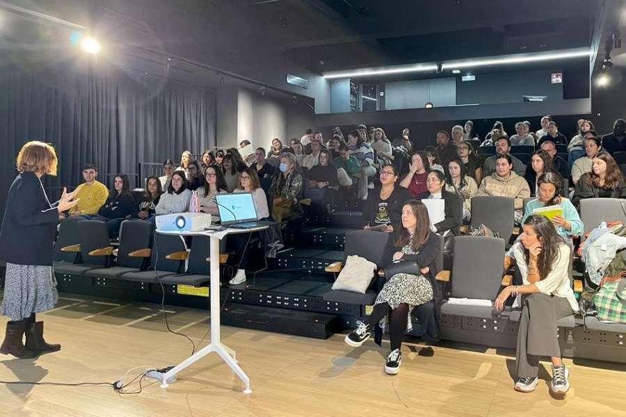 Sala de formación con una ponente explicando y unas 65 personas atendiendo 