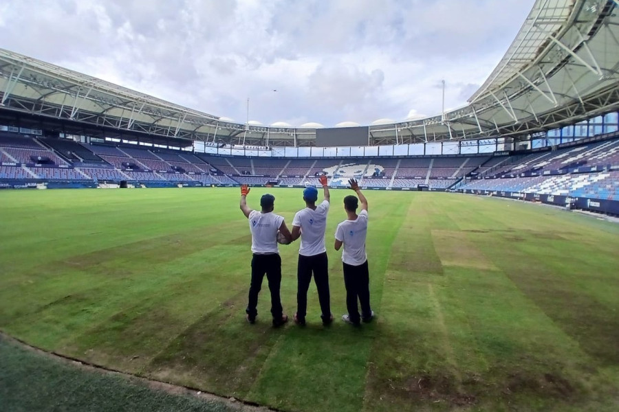 Tres de los jóvenes posan en el estadio con el trabajo casi finalizado