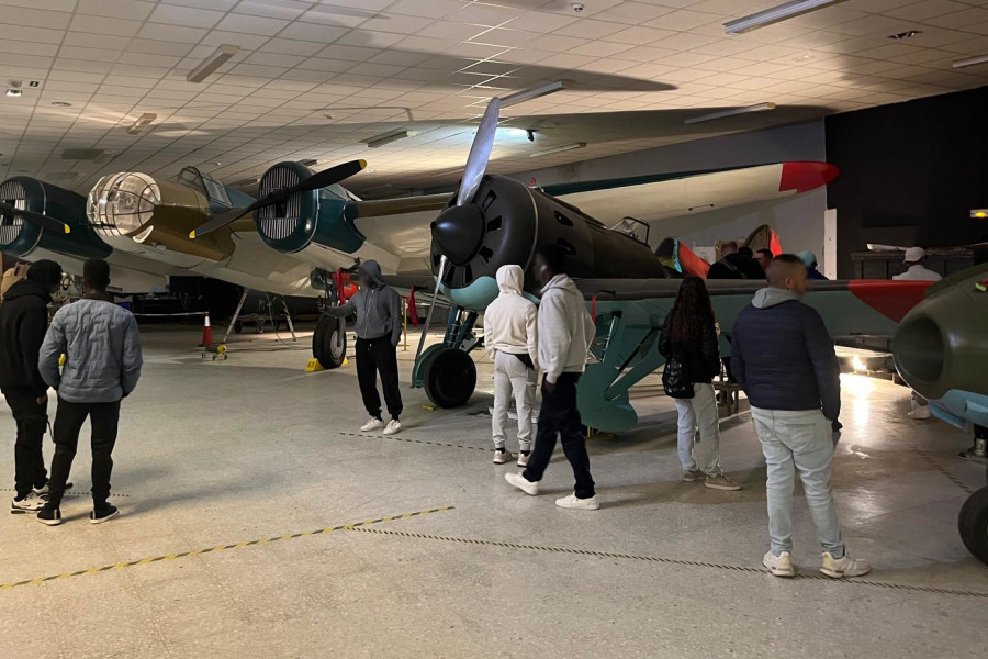 Varios jóvenes observan el hangar con aviones de la época