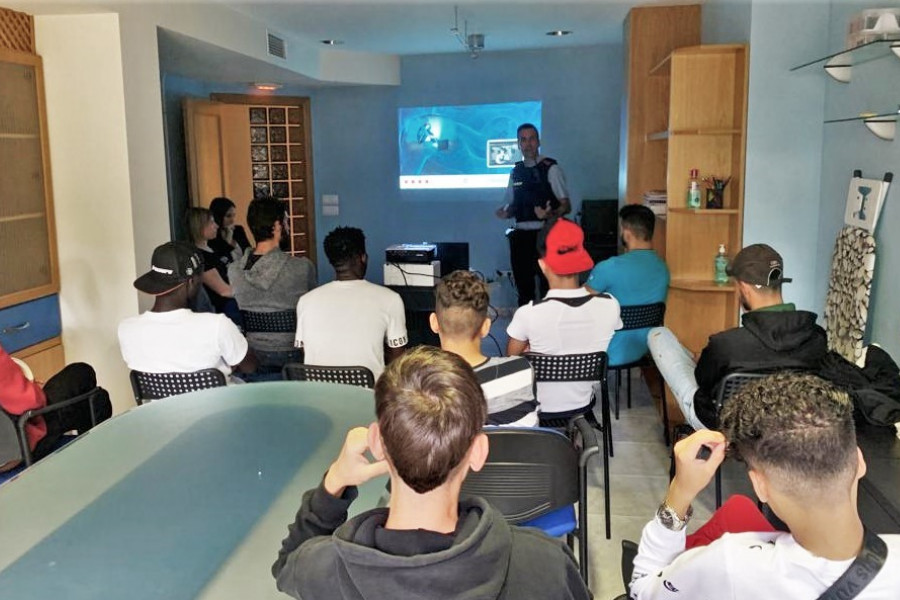 Un mosso d'esquadra realiza la presentación de ciberseguridad ante varios jóvenes