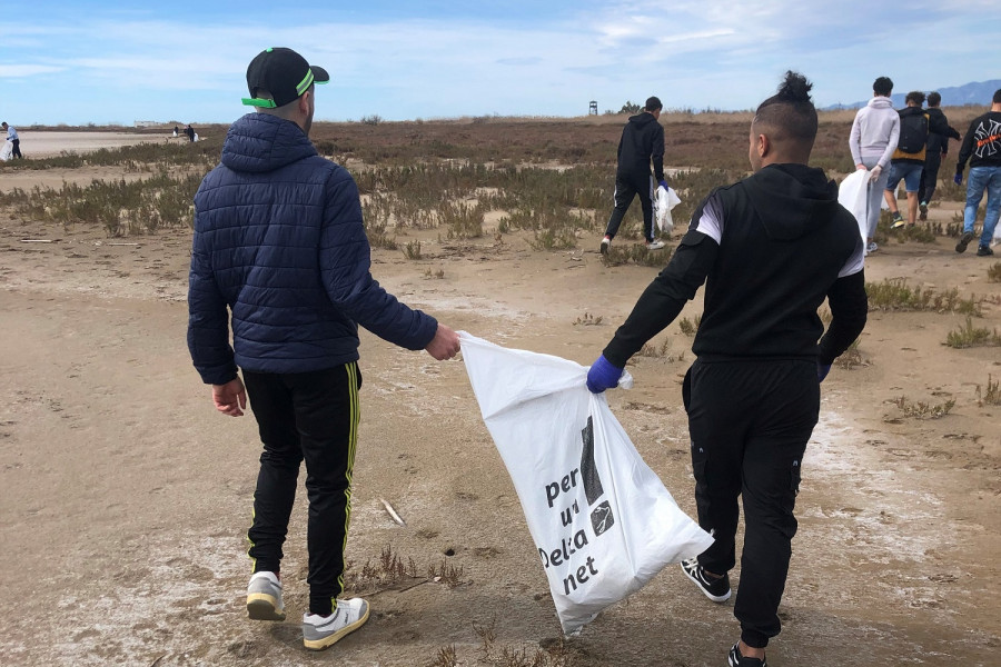 Dos jóvenes del centro, con una bolsa medio llena de los residuos que han ido recogiendo