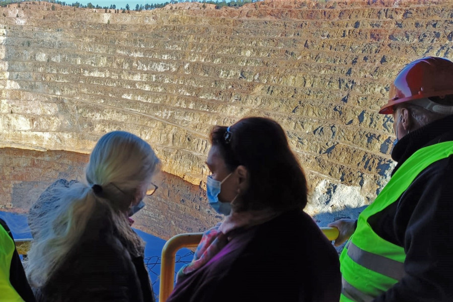 Tres personas mayores observan la explotación minera