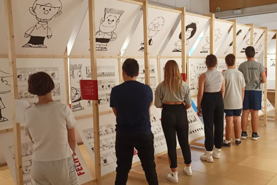 Los jóvenes observan algunos de los diseños y tiras cómicas de Mafalda