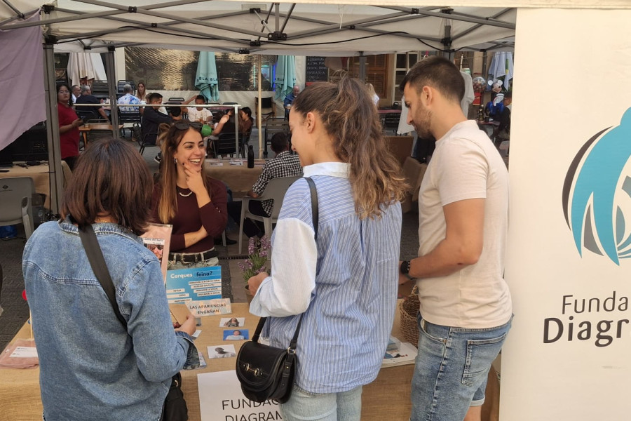 Tres personas se acercan a la mesa informativa de Fundación Diagrama