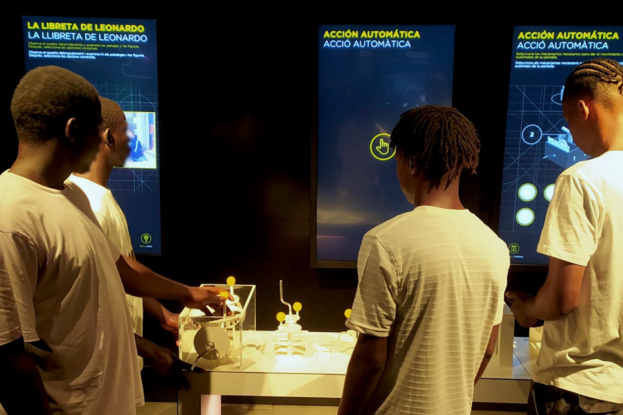 Los cuatro jóvenes prueban uno de los juegos interactivos de la exposición