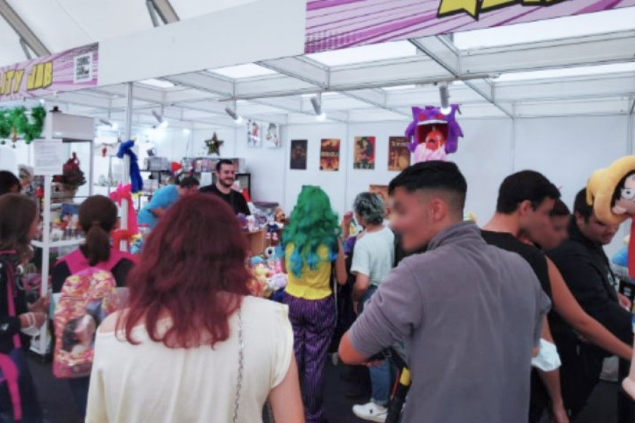 Un grupo de gente visita uno de los puestos de la feria