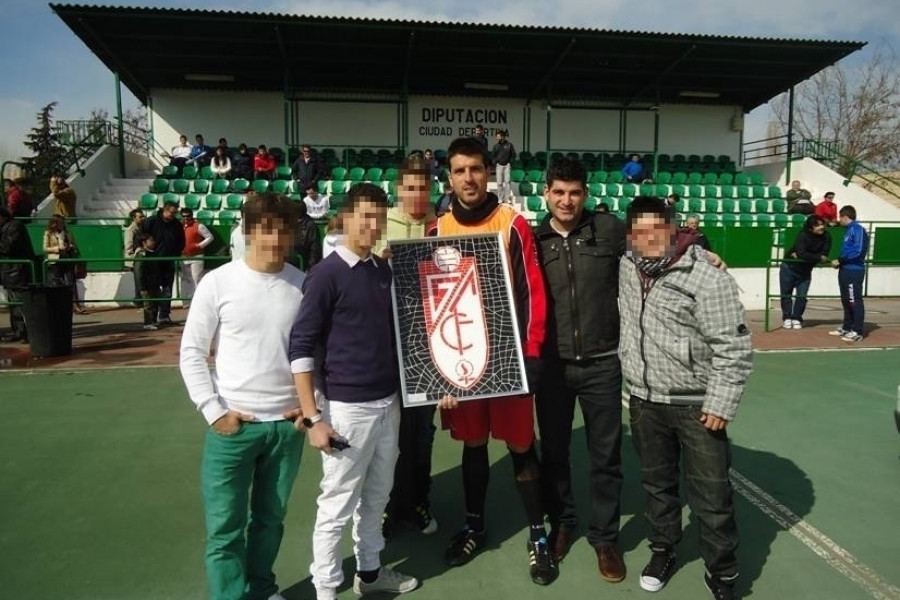 Jóvenes del Centro ‘San Miguel’ asisten a un entrenamiento del Granada Club de Fútbol y entregan a los jugadores un mosaico del club realizado por ellos mismos