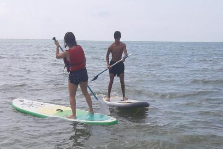 Los jóvenes atendidos en la Unidad de Fomento de la Autonomía ‘Migjorn’ de Tortosa (Tarragona) participan en una jornada de paddle surf