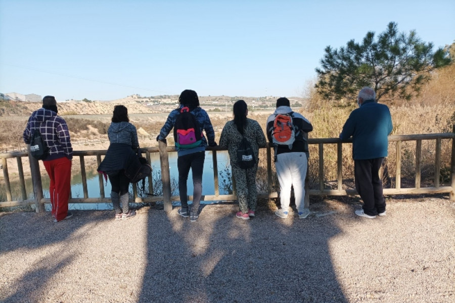 Grupo de 6 personas participantes en la ruta senderista observan el río desde un mirador