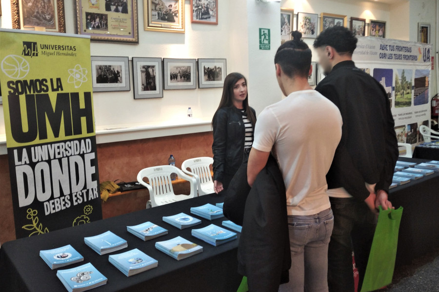 Dos jóvenes en la mesa de la UMH en la VI Feria de Orientación Educativa y Laboral ‘Orienta-t’ de Petrer