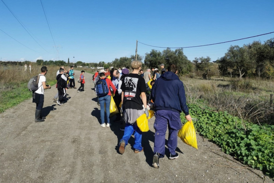 El grupo de voluntarios y voluntarias se reúne en un camino para comenzar la labor de limpieza