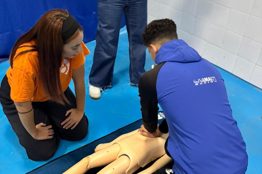Uno de los jóvenes practica la RCP con el maniquí