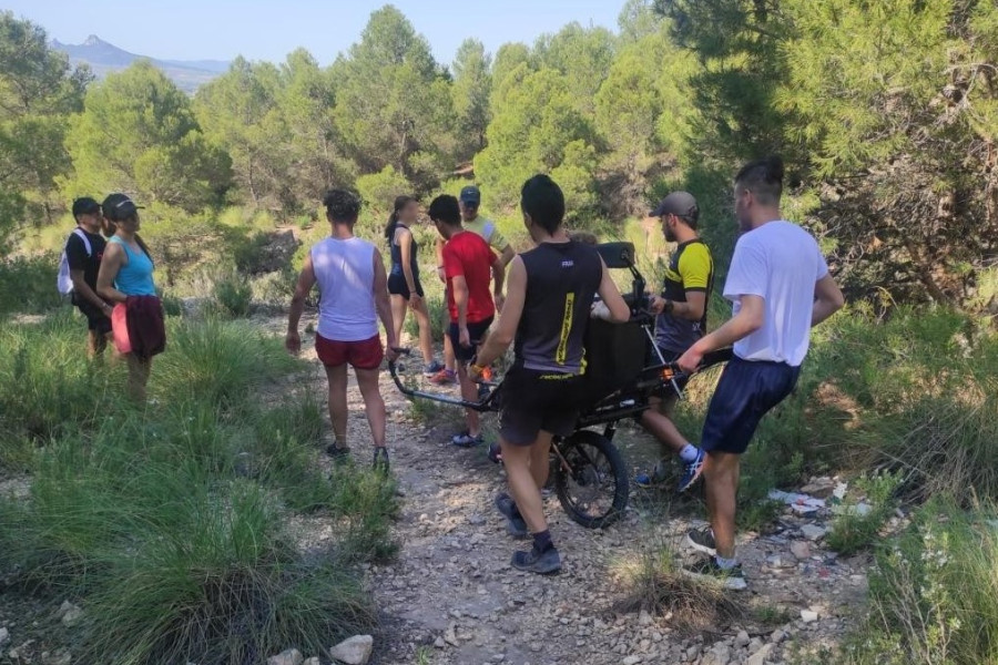 Los jóvenes ayudan a la usuaria a realizar la ruta