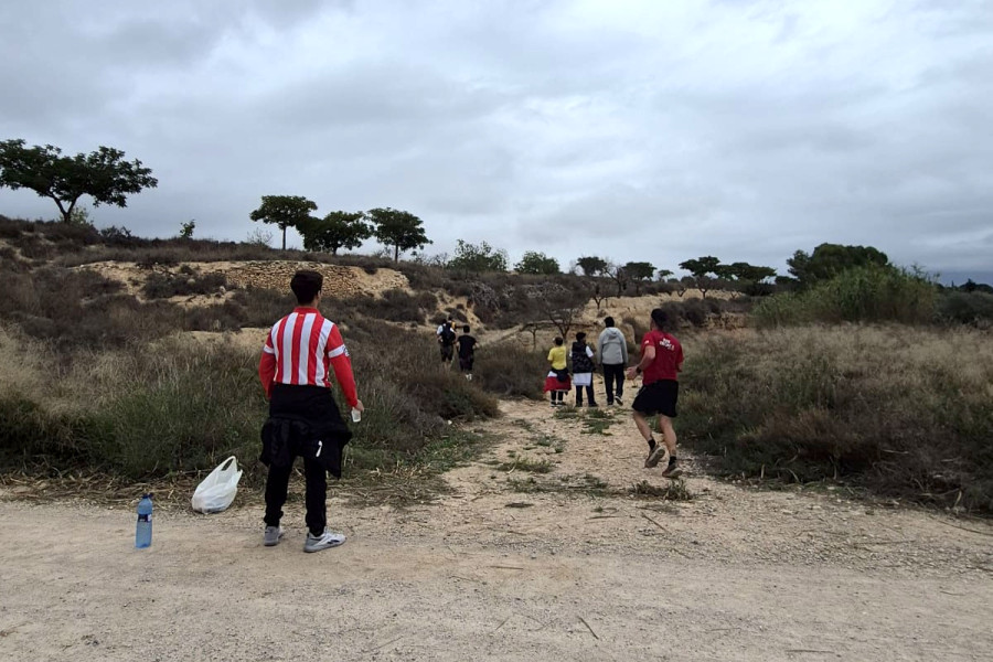 Un joven se acerca a un tramo de ruta para ofrecer agua a los corredores