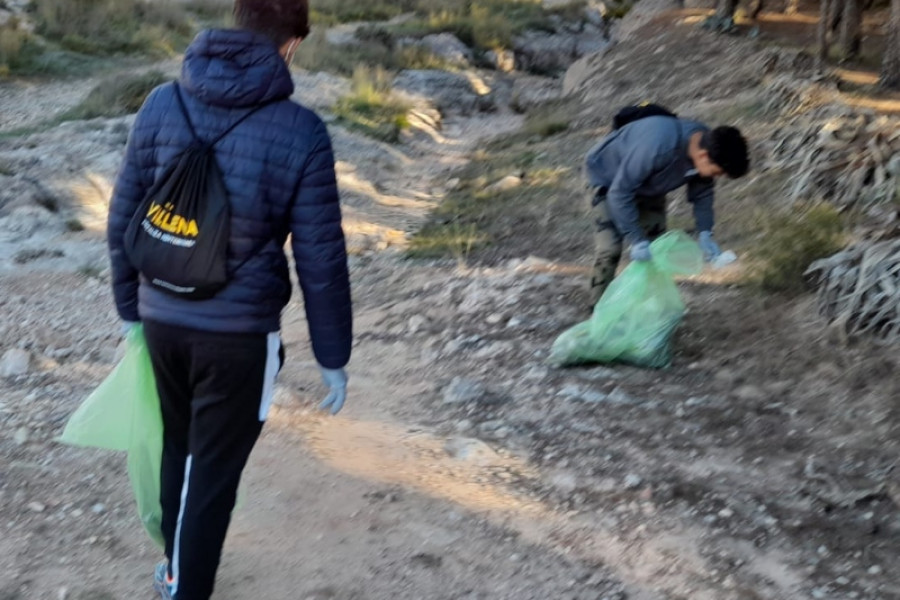 Tres jóvenes en la residencia ‘La Villa’ de Villena (Alicante) colaboran en una acción de voluntariado medioambiental en el Paraje de las Cruces