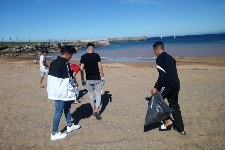 Los jóvenes atendidos en el centro ‘Villa Ana’ en Avilés (Asturias) participan en una actividad de recogida de residuos en las playas de Luanco 
