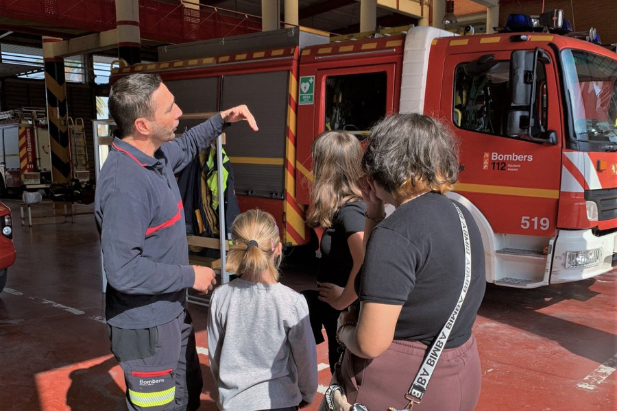 Un bombero explica a las tres jóvenes la labor que realizan en el parque