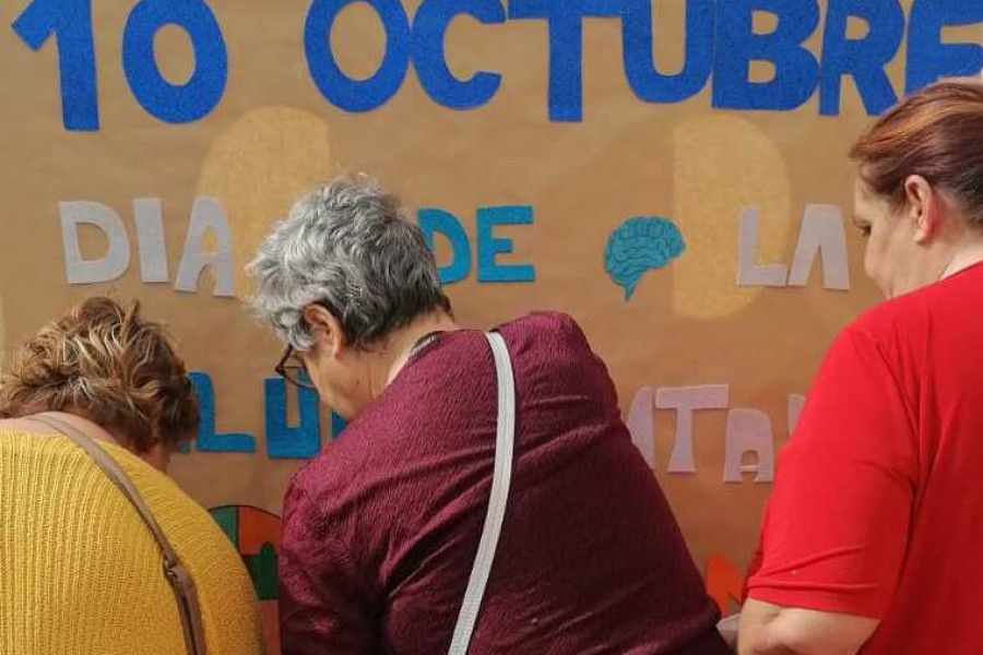 Mujeres colocan mural conmemorativo del Día Mundial de la Salud Mental